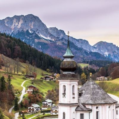 Church of Maria Gern, bavarian village and mountains on a background at sunrise. Bavarian alps.